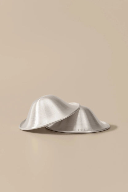 Le Lolo 999 silver nursing cups with intricate engraved design on shiny silver surface for traditional decorative use