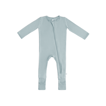 Baby in soft bamboo pajamas with DreamCuffs® from Dreamland Baby, featuring cozy footed design and gentle fabric for comfort.