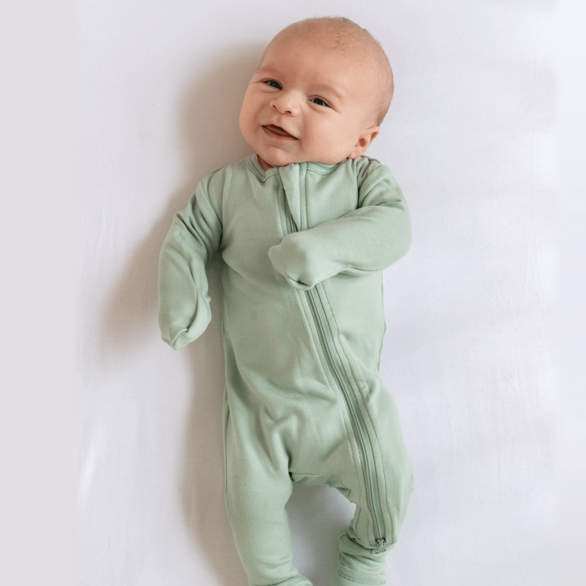 Cute baby bamboo pajamas with DreamCuffs® from Dreamland Baby, featuring soft fabric and adjustable cuffs for comfort.