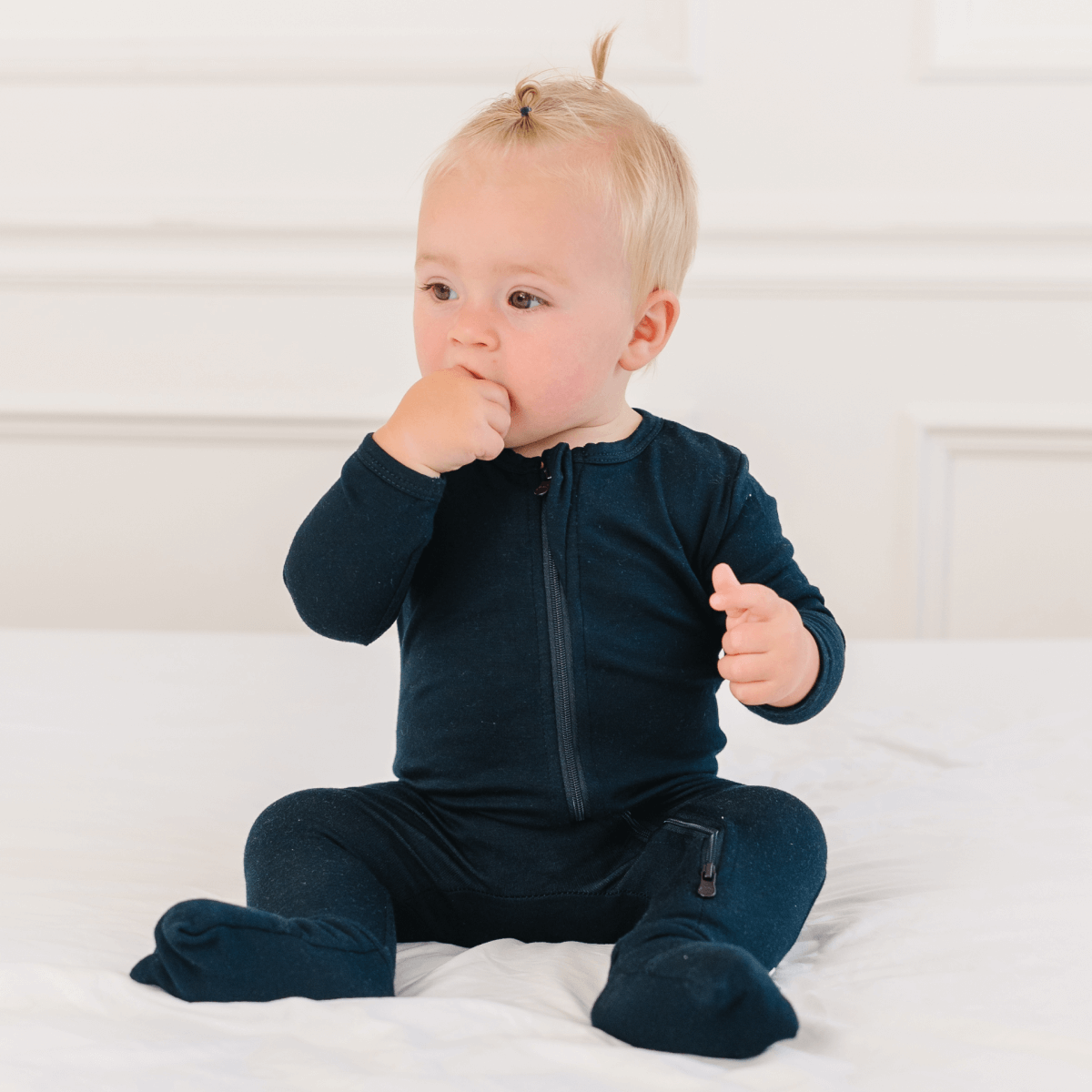 Baby wearing Dreamland Baby bamboo pajamas with DreamCuffs®, featuring soft fabric and snug fit for comfortable sleep.