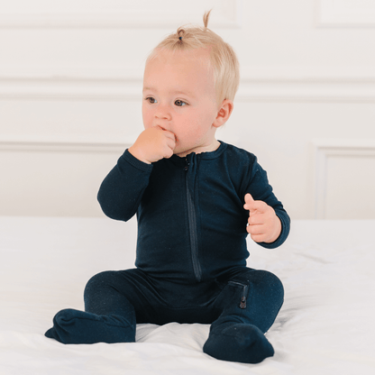 Baby wearing Dreamland Baby bamboo pajamas with DreamCuffs®, featuring soft fabric and snug fit for comfortable sleep.