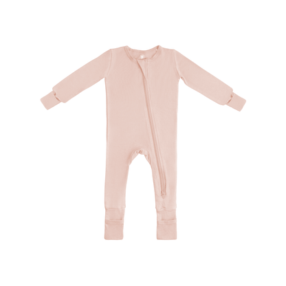 Baby in soft bamboo pajamas with DreamCuffs® from Dreamland Baby, lying peacefully in cozy sleepwear.