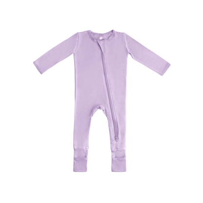 Baby in Dreamland Baby bamboo pajamas with DreamCuffs®, soft fabric and snug fit, lying on a cozy bed.