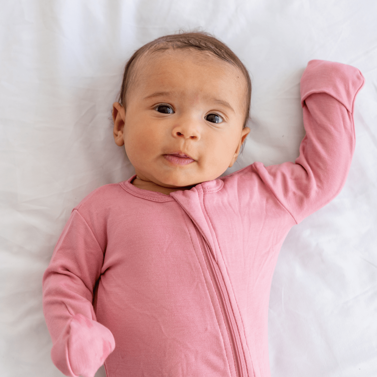 Baby wearing Dreamland Baby Bamboo Pajamas with DreamCuffs®, showing soft, breathable fabric and snug fit for comfort.