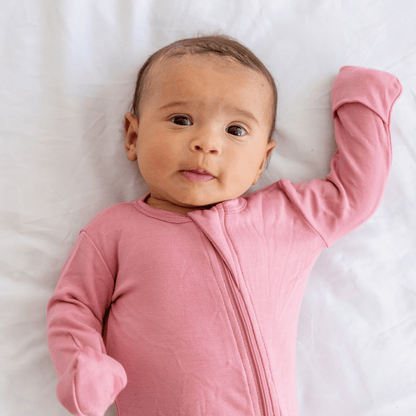 Baby wearing Dreamland Baby Bamboo Pajamas with DreamCuffs®, showing soft, breathable fabric and snug fit for comfort.