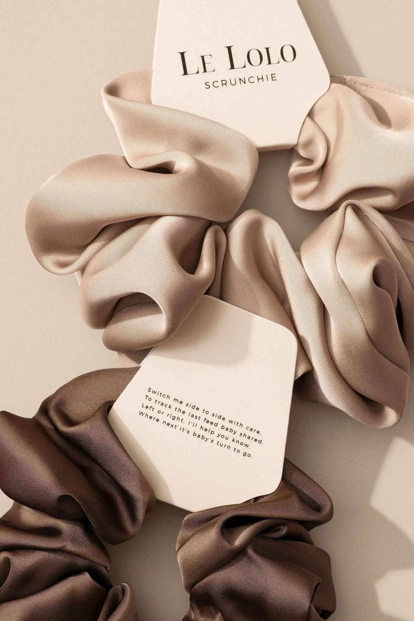 Le Lolo breastfeeding reminder scrunchie with an elastic band and fabric covering for easy nursing reminders and hair styling.