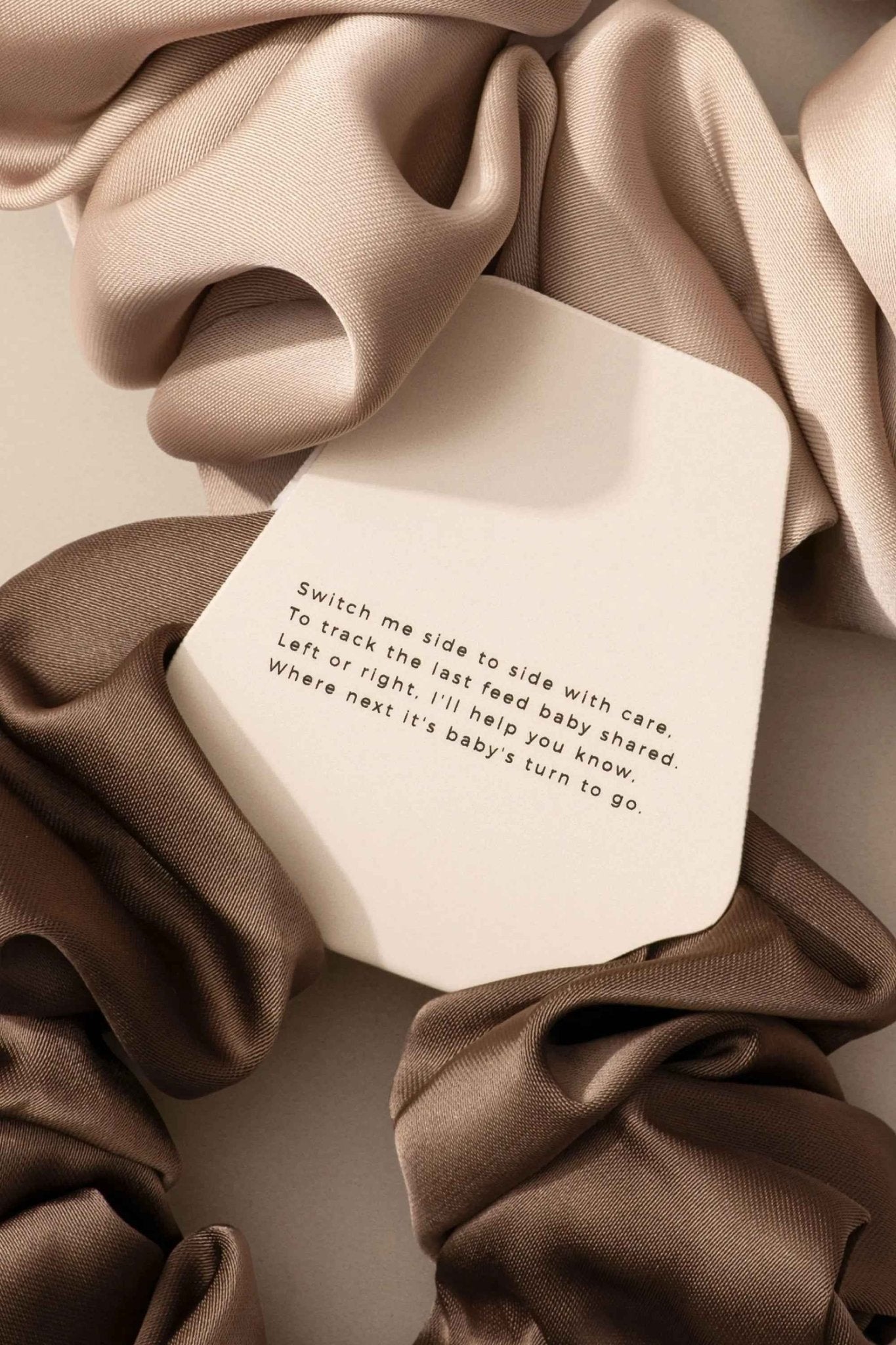 Le Lolo breastfeeding reminder scrunchie in soft fabric with a discreet label, designed for moms to keep track of feeding times.