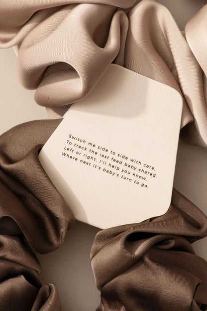 Le Lolo breastfeeding reminder scrunchie in soft fabric with a discreet label, designed for moms to keep track of feeding times.