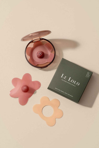 Colored nipple shield system by Le Lolo showing vibrant, soft silicone shields with adjustable straps for comfortable nipple protection.