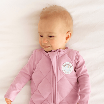 Dreamland Baby weighted sleep sack lying open, showing soft fabric and adjustable straps, designed for comfortable sleep.