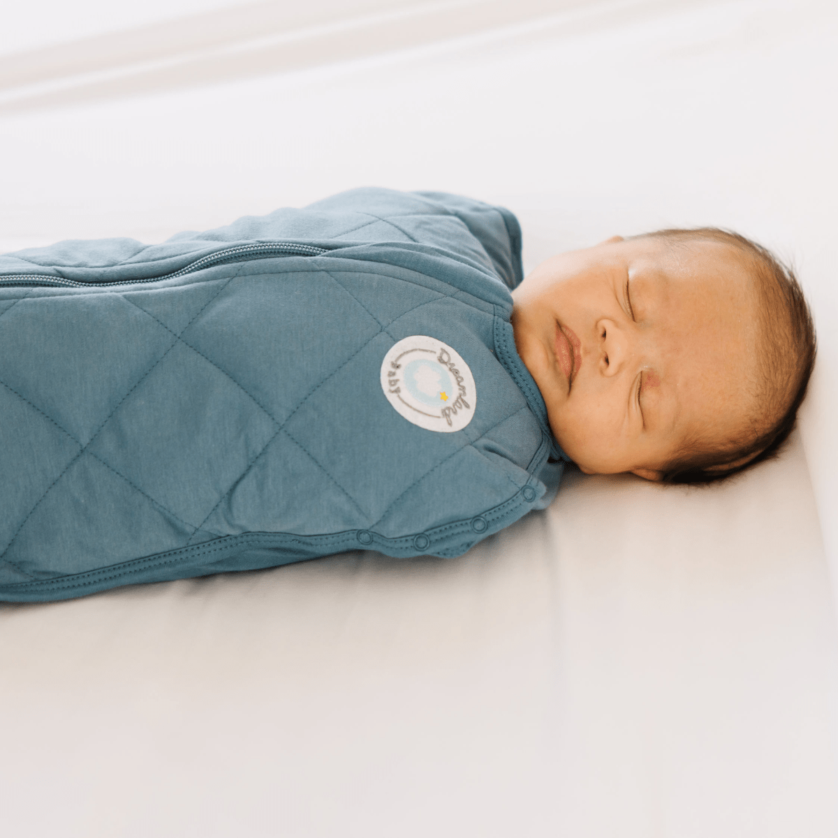 Dreamland Baby weighted sleep swaddle in soft fabric, designed to provide calming comfort for infants during sleep.