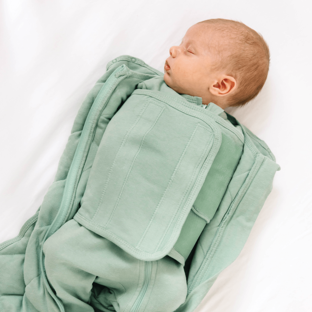 Dreamland Baby Dream Weighted Sleep Swaddle, soft fabric with adjustable straps, designed to promote peaceful sleep for infants.