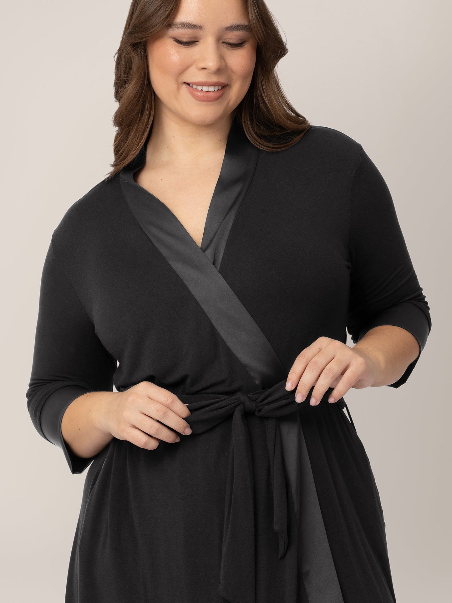 Black Emmaline Robe by Kindred Bravely, soft fabric with a relaxed fit, shown hanging on a hook.