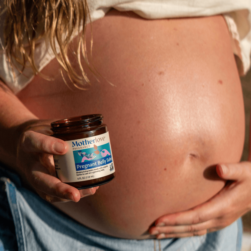 Motherlove Herbal Company pregnancy belly salve applied on a pregnant woman's belly, moisturizing and soothing skin during pregnancy.