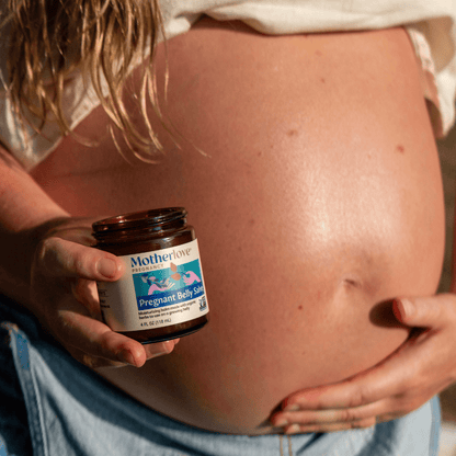 Motherlove Herbal Company pregnancy belly salve applied on a pregnant woman's belly, moisturizing and soothing skin during pregnancy.