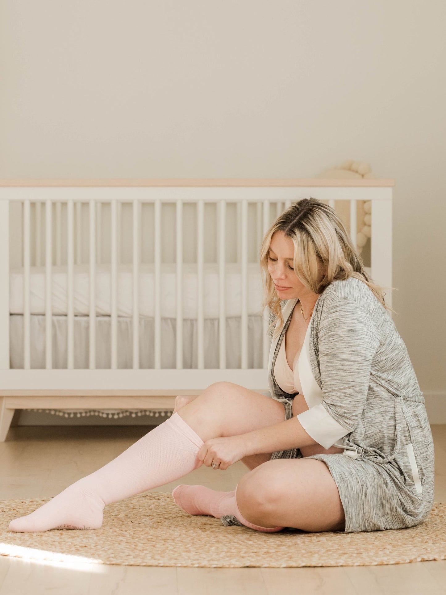 Pair of Kindred Bravely premium maternity compression socks in soft pink and grey Heather, designed for comfort and support.