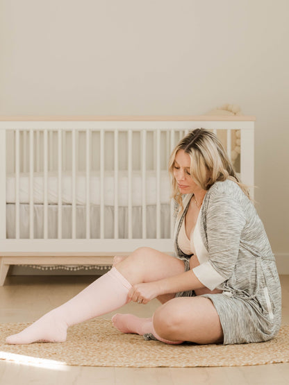 Pair of Kindred Bravely premium maternity compression socks in soft pink and grey Heather, designed for comfort and support.