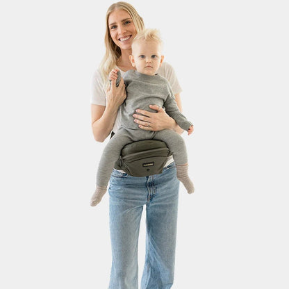 Baby wearing the Tushbaby Hip Carrier, a comfortable toddler carrier with supportive waist belt and adjustable straps for easy carrying.