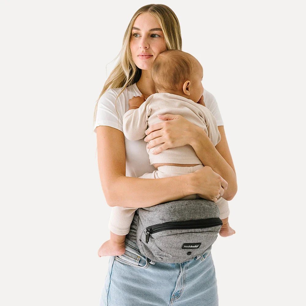 Tushbaby Hip Carrier for baby and toddler, showing a comfortable, adjustable ergonomic baby carrier in neutral color.