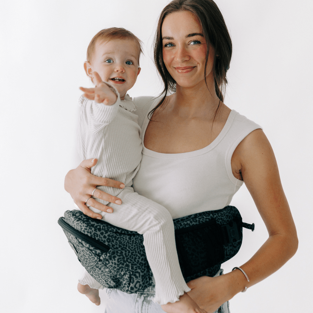 Tushbaby Hip Carrier for babies and toddlers, black ergonomic design with padded straps and waistband for comfortable carrying.
