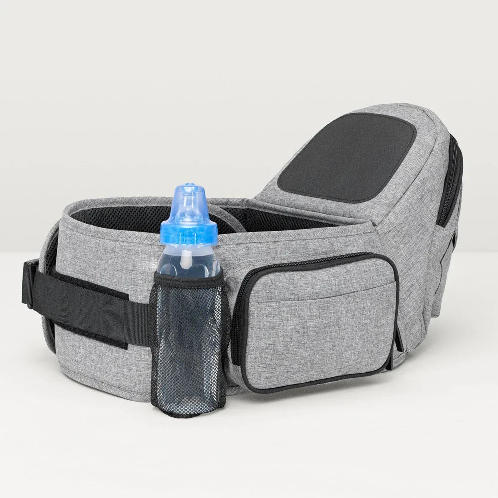 Baby wearing the Tushbaby Hip Carrier, a comfortable and supportive carrier for parents to carry their toddler securely.