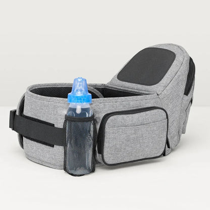 Baby wearing the Tushbaby Hip Carrier, a comfortable and supportive carrier for parents to carry their toddler securely.