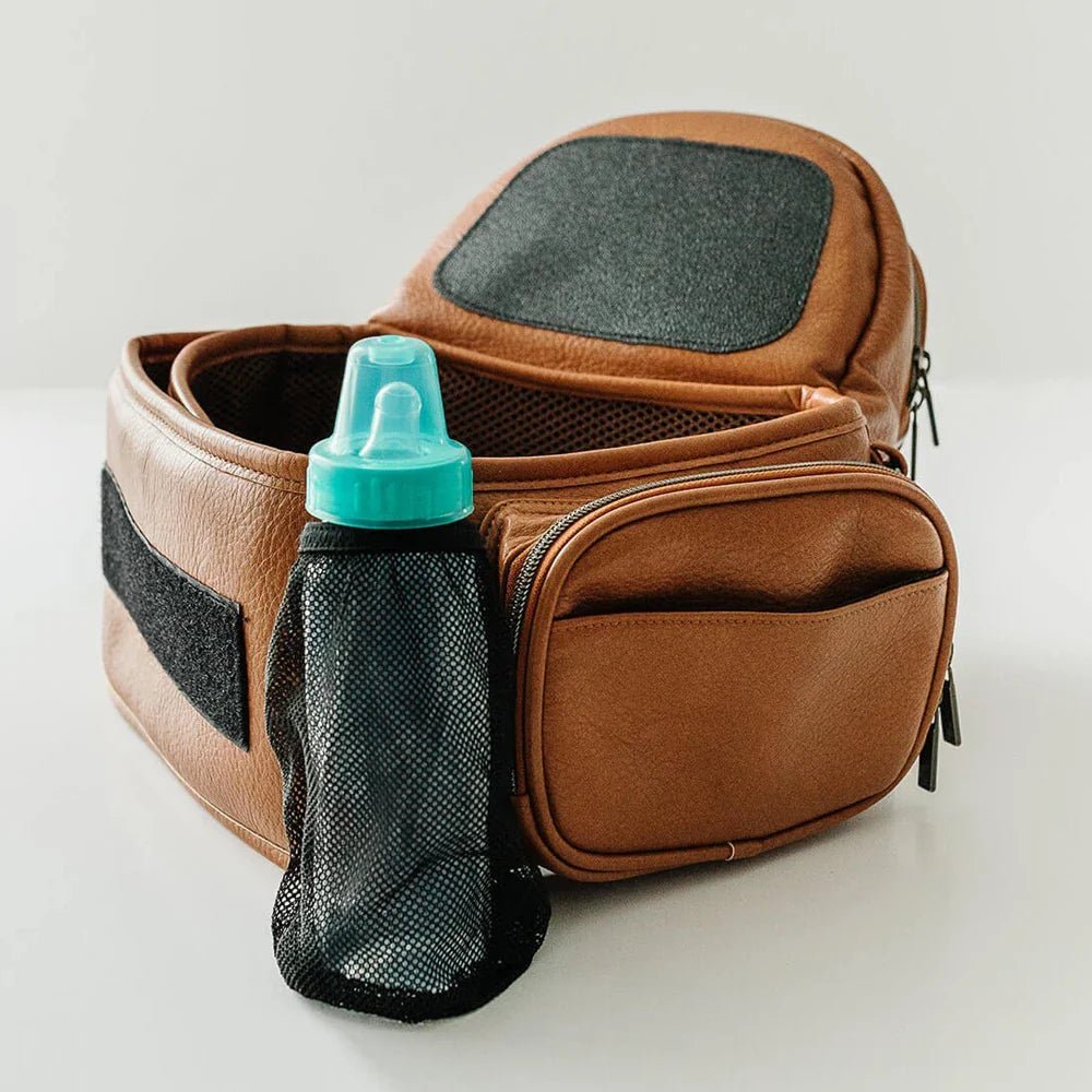Tushbaby Hip Carrier for babies and toddlers in gray, with supportive waist belt and adjustable straps for comfortable carrying.