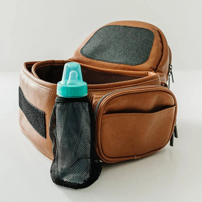 Tushbaby Hip Carrier for babies and toddlers in gray, with supportive waist belt and adjustable straps for comfortable carrying.