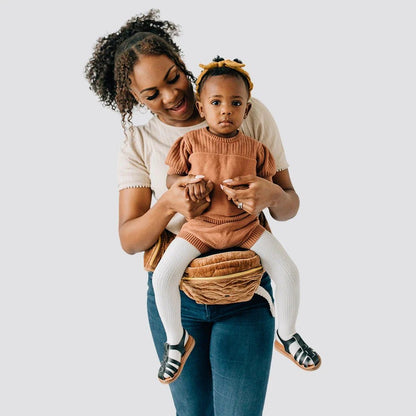 Tushbaby Hip Carrier for babies and toddlers, black fabric with padded waistband and adjustable straps, worn around the hips.
