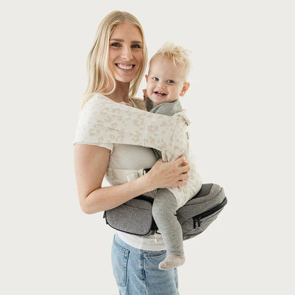 Tushbaby Hip Carrier for babies and toddlers, showing a parent wearing the ergonomic carrier with a child seated comfortably.