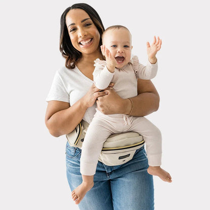Baby wearing the Tushbaby Hip Carrier, a comfortable and supportive toddler carrier in a neutral color, showcasing its ergonomic design.