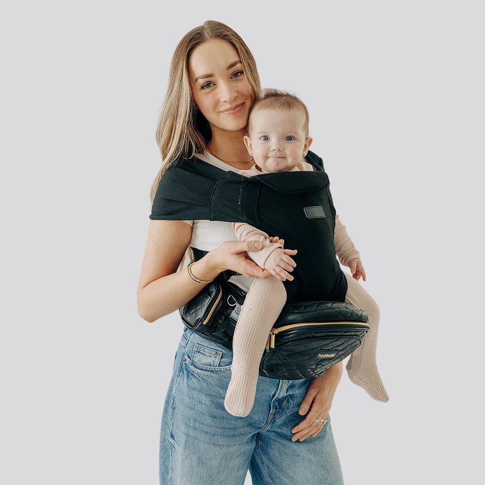 Tushbaby Hip Carrier for babies and toddlers showing the adjustable belt and padded seat in a natural setting