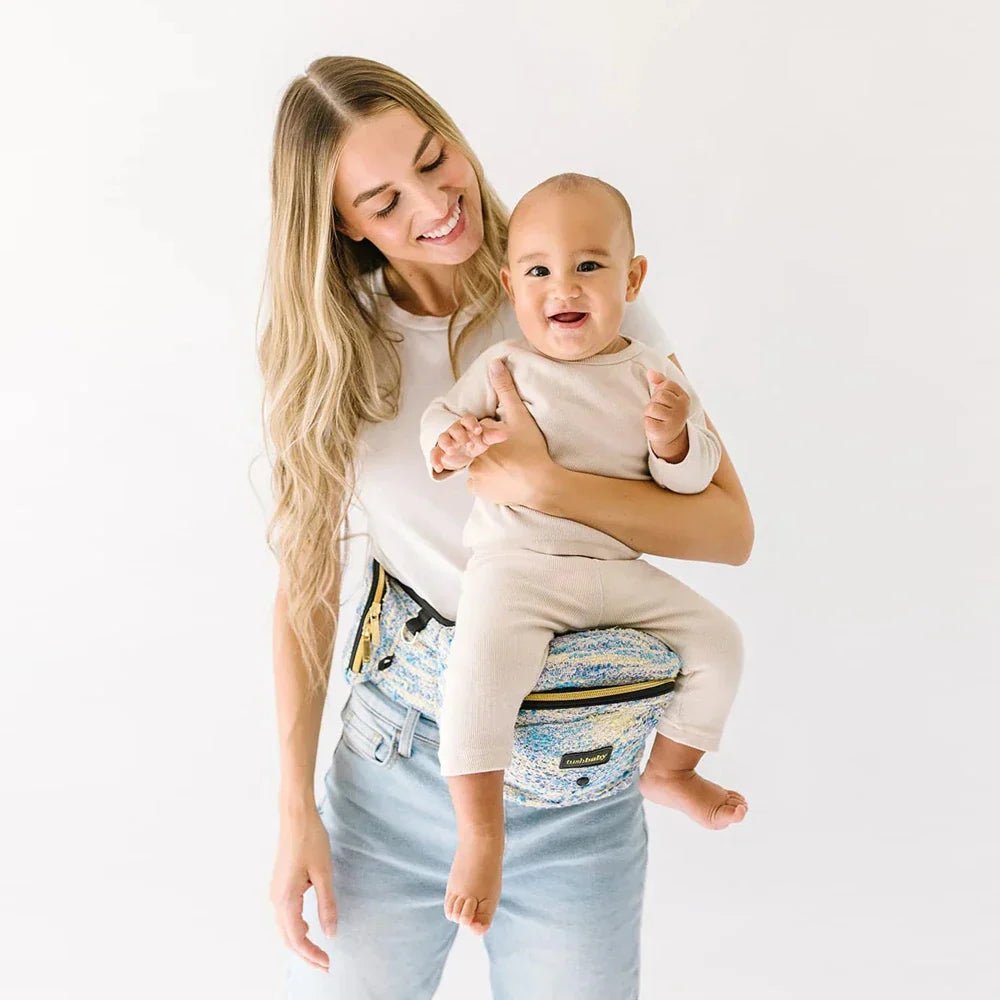 Tushbaby Hip Carrier for baby and toddler, showing adjustable strap and cushioned support in a neutral color.
