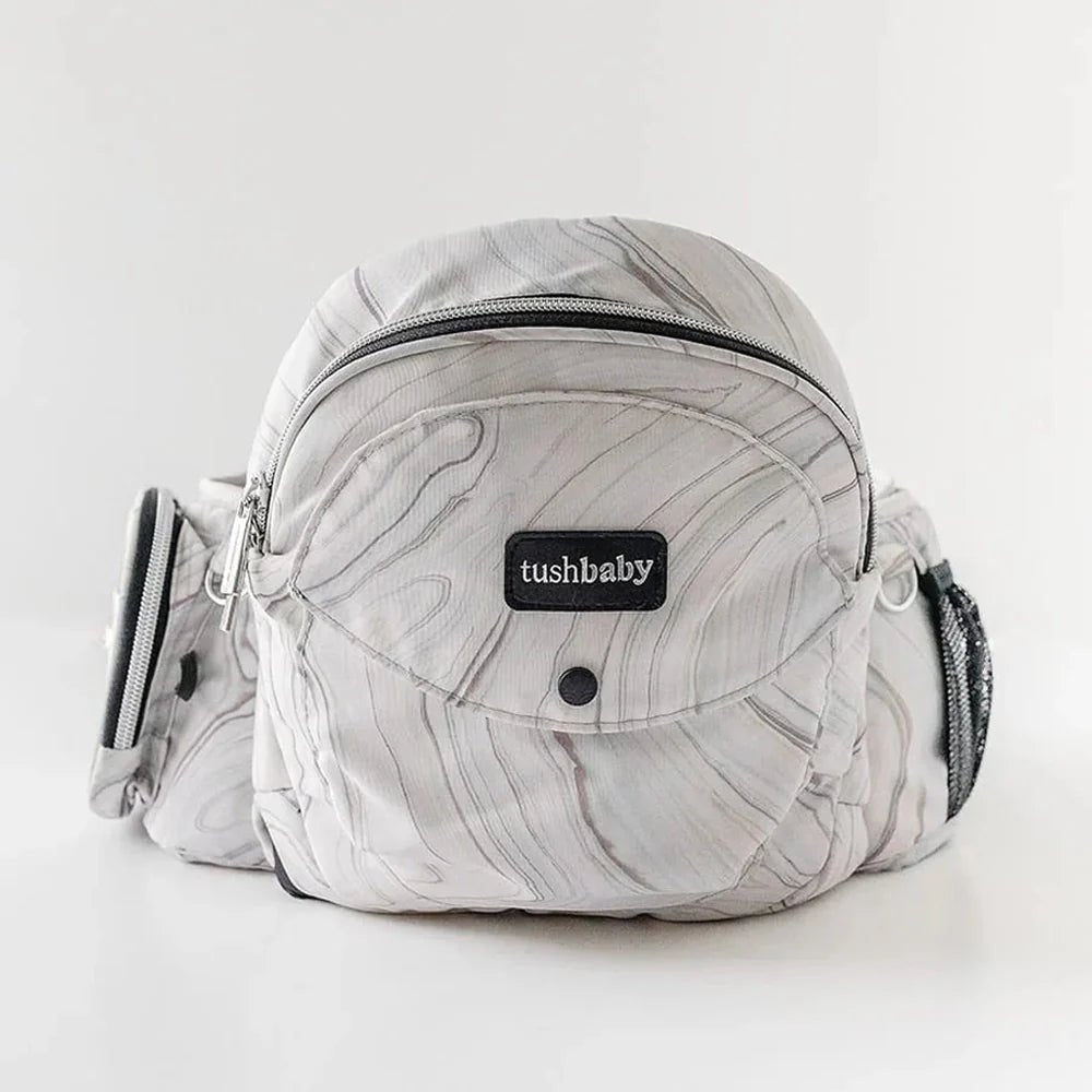 Tushbaby Hip Carrier for babies and toddlers, showing the ergonomic design and adjustable straps in a neutral color.