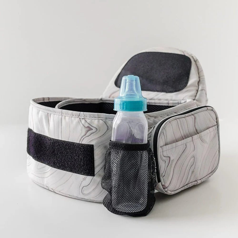 Tushbaby Hip Carrier for babies and toddlers, beige fabric with adjustable straps, designed for comfortable parent-child carrying