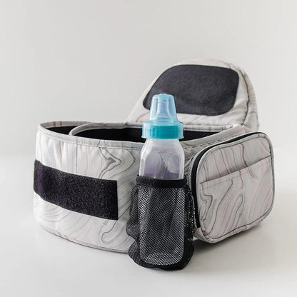 Tushbaby Hip Carrier for babies and toddlers, beige fabric with adjustable straps, designed for comfortable parent-child carrying
