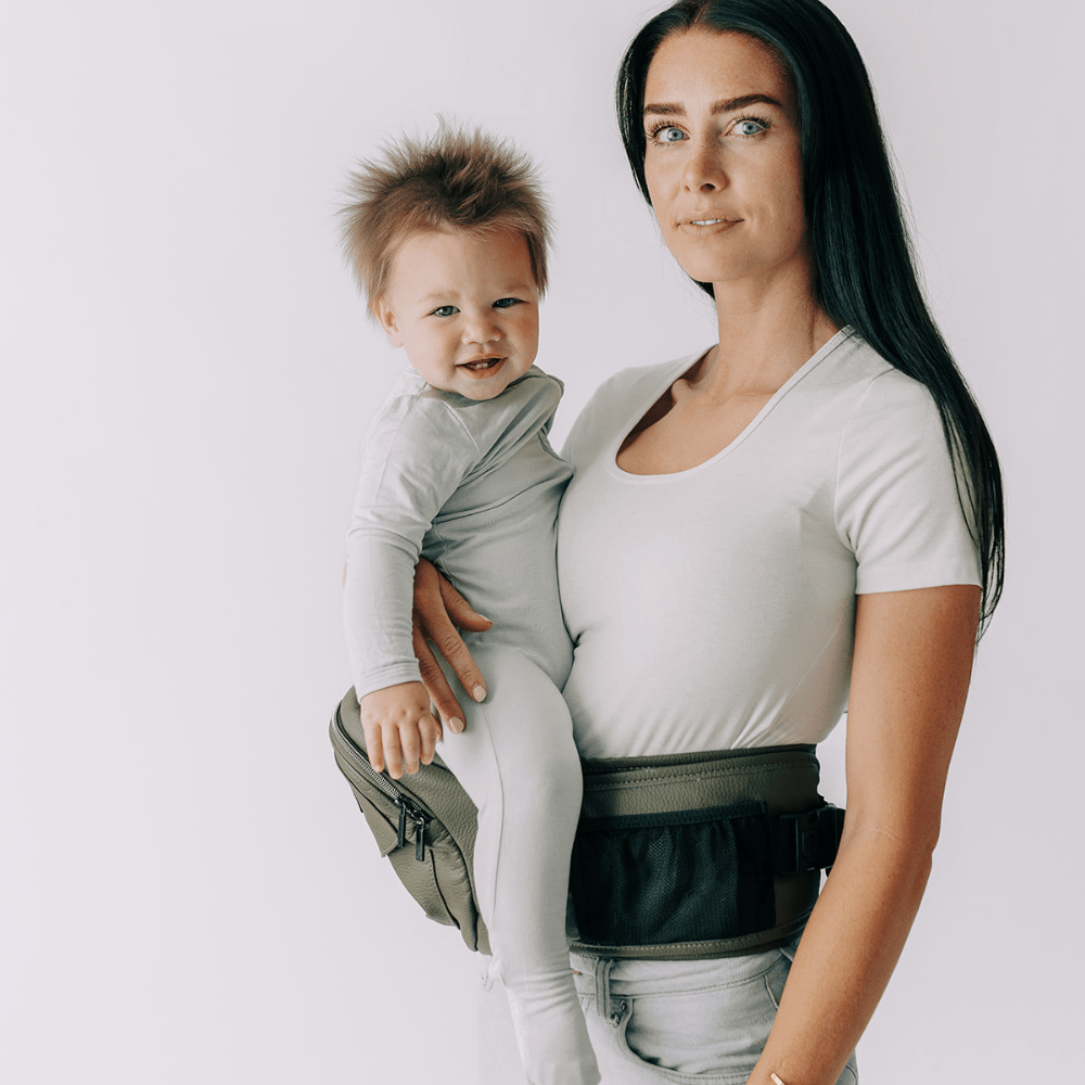 Tushbaby hip carrier for babies and toddlers, showing ergonomic design and adjustable straps in a neutral color.