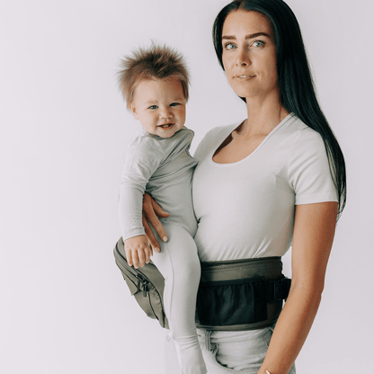 Tushbaby hip carrier for babies and toddlers, showing ergonomic design and adjustable straps in a neutral color.