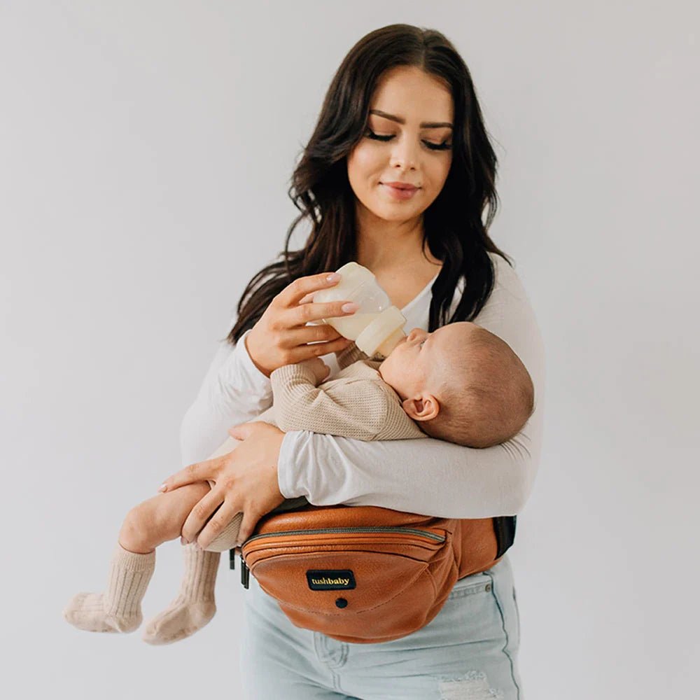 Tushbaby hip carrier for baby and toddler, with padded straps and ergonomic design for comfortable carrying.