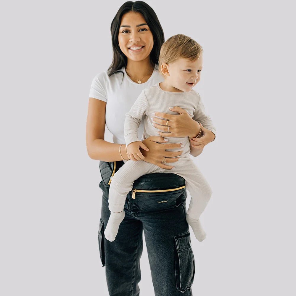 Tushbaby Hip Carrier for babies and toddlers, featuring padded straps and adjustable support for comfortable carrying.