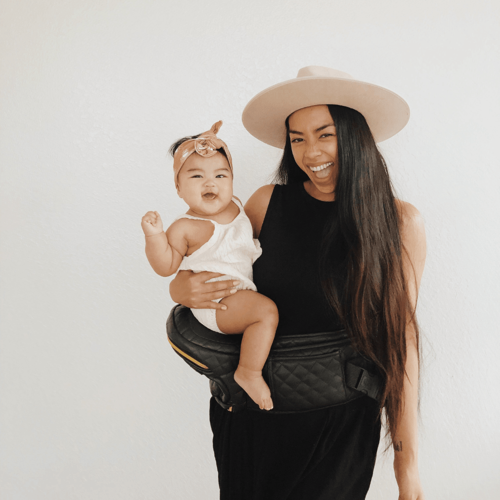 Tushbaby Hip Carrier for babies and toddlers, featuring ergonomic design and adjustable straps for comfortable carrying.