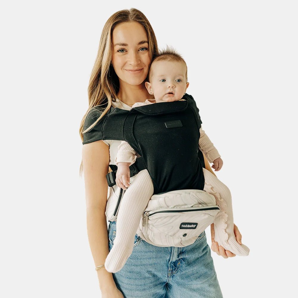 Tushbaby Hip Carrier for babies and toddlers showing the ergonomic seat and adjustable straps in a natural setting