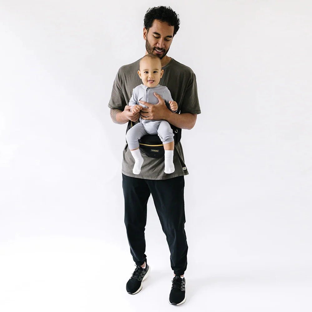 Tushbaby Hip Carrier for babies and toddlers, shown in use with a child secured comfortably on a parent’s hip.