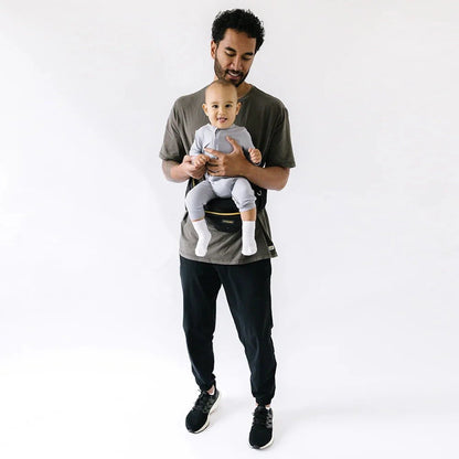 Tushbaby Hip Carrier for babies and toddlers, shown in use with a child secured comfortably on a parent’s hip.
