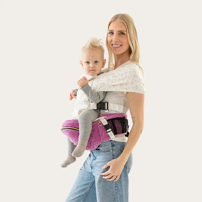 Tushbaby Hip Carrier for babies and toddlers, showing ergonomic design and adjustable straps in a natural setting.