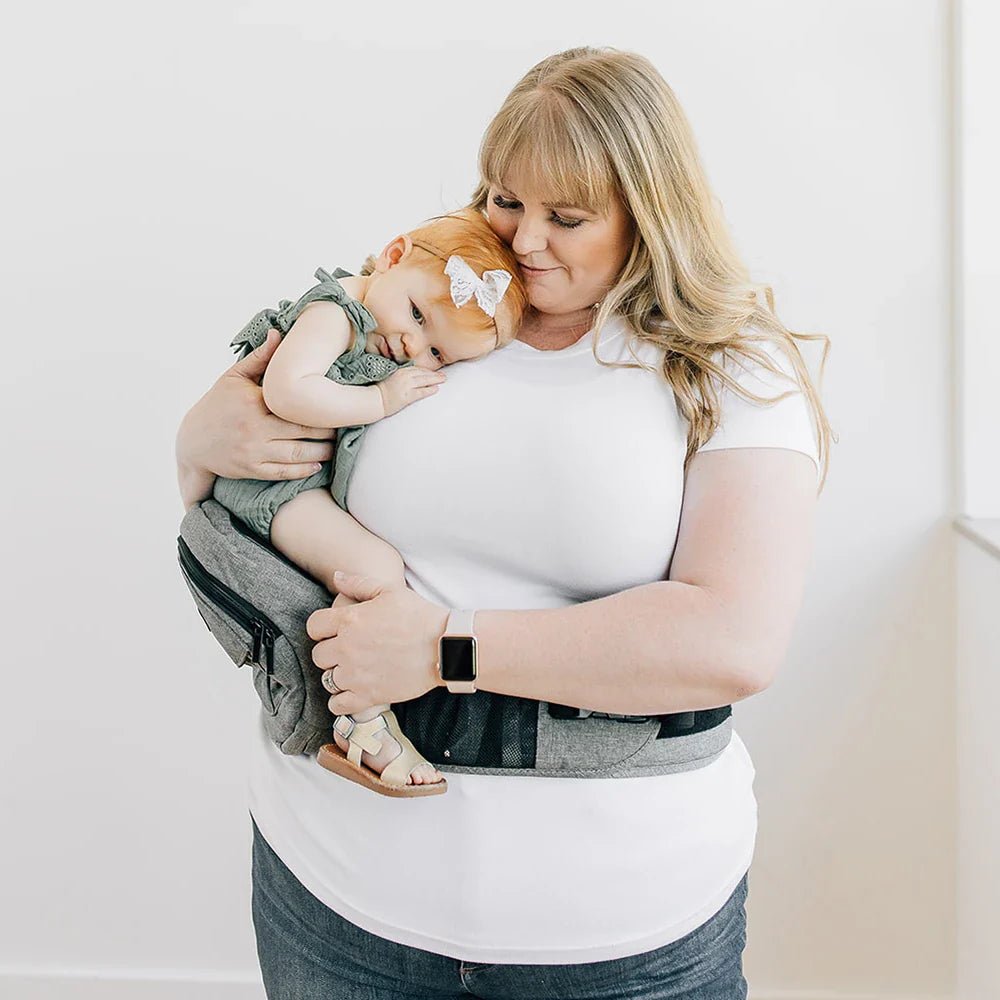 Tushbaby Hip Carrier for baby and toddler, showing ergonomic design and adjustable straps in a neutral color.