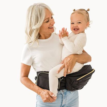 Baby and toddler hip carrier by Tushbaby in soft fabric, designed for comfortable carrying and support.