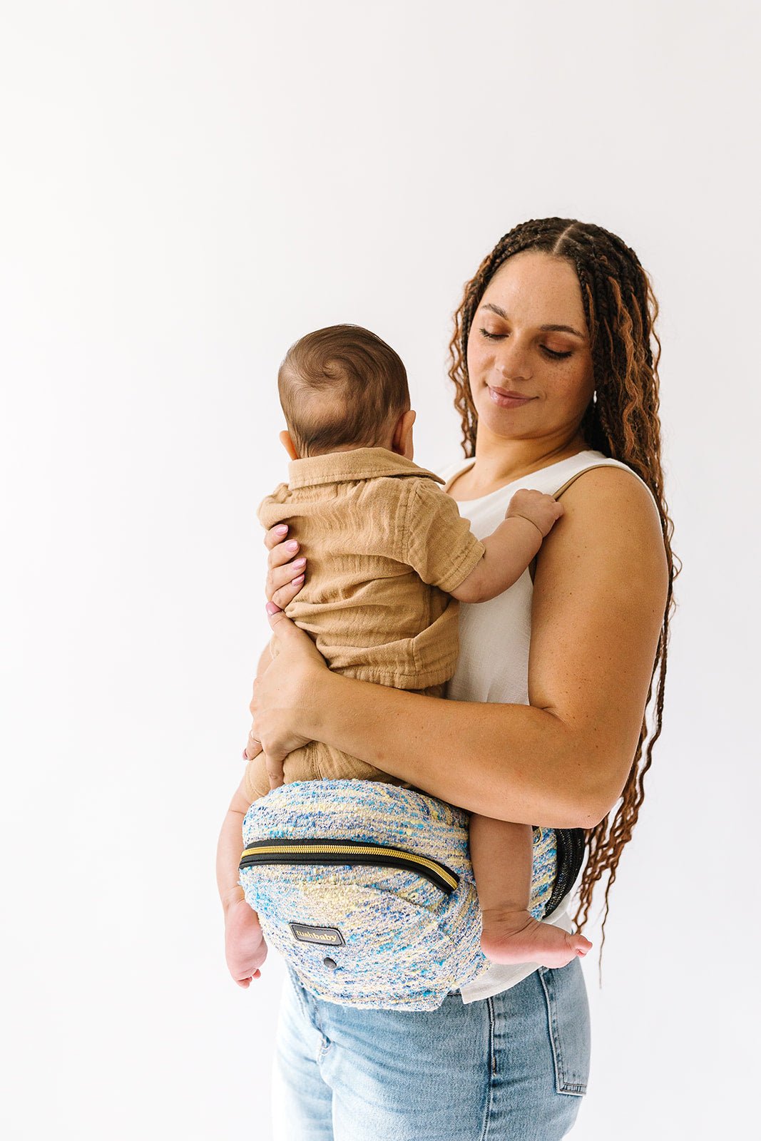 Tushbaby Hip Carrier for baby and toddler, showing the ergonomic design and adjustable straps for comfortable carrying.