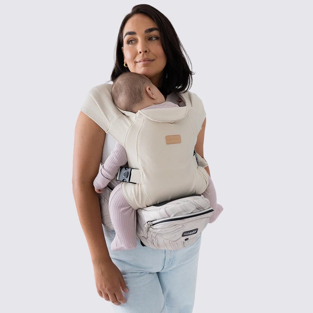 Tushbaby hip carrier for baby and toddler, showing adjustable straps and ergonomic design for comfortable carrying.