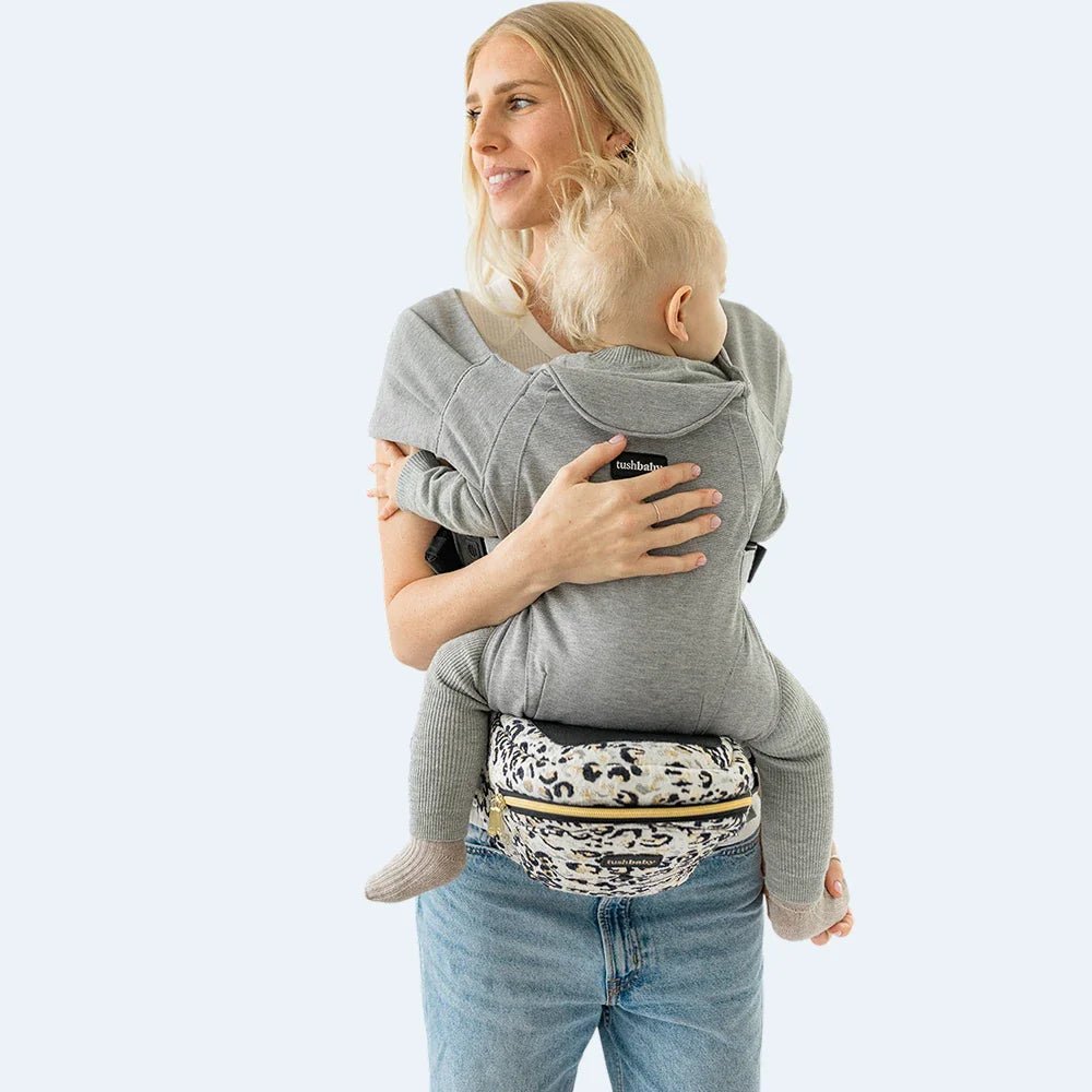 Baby and toddler hip carrier by Tushbaby, shown in a soft fabric with adjustable straps and ergonomic design for comfortable carrying.